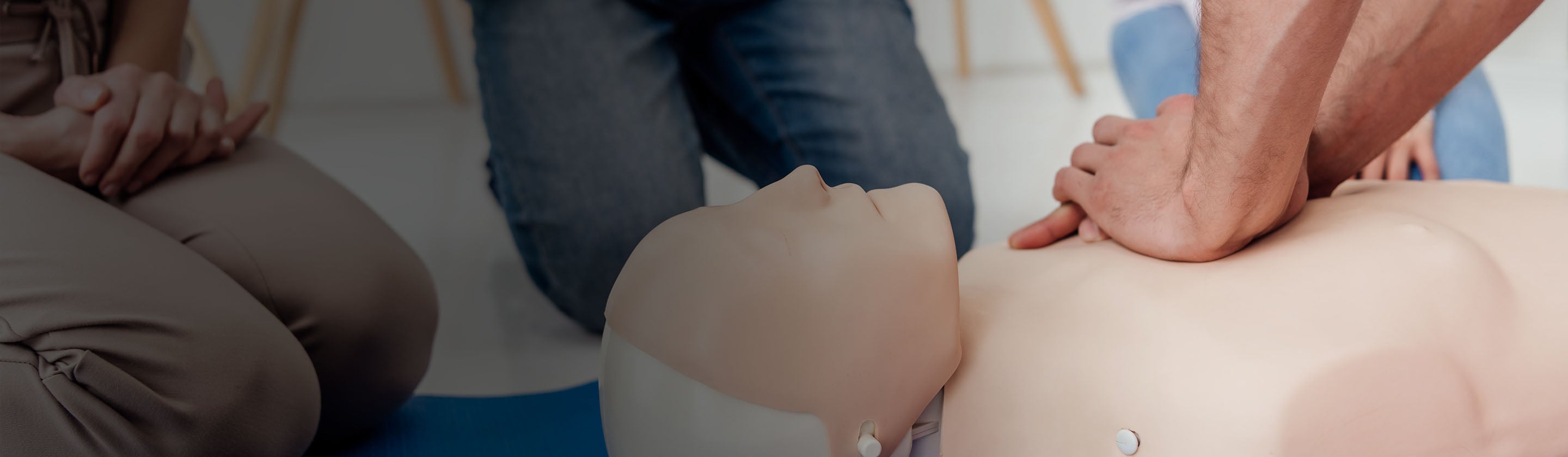 Person performing CPR on a mannequin during a training session.